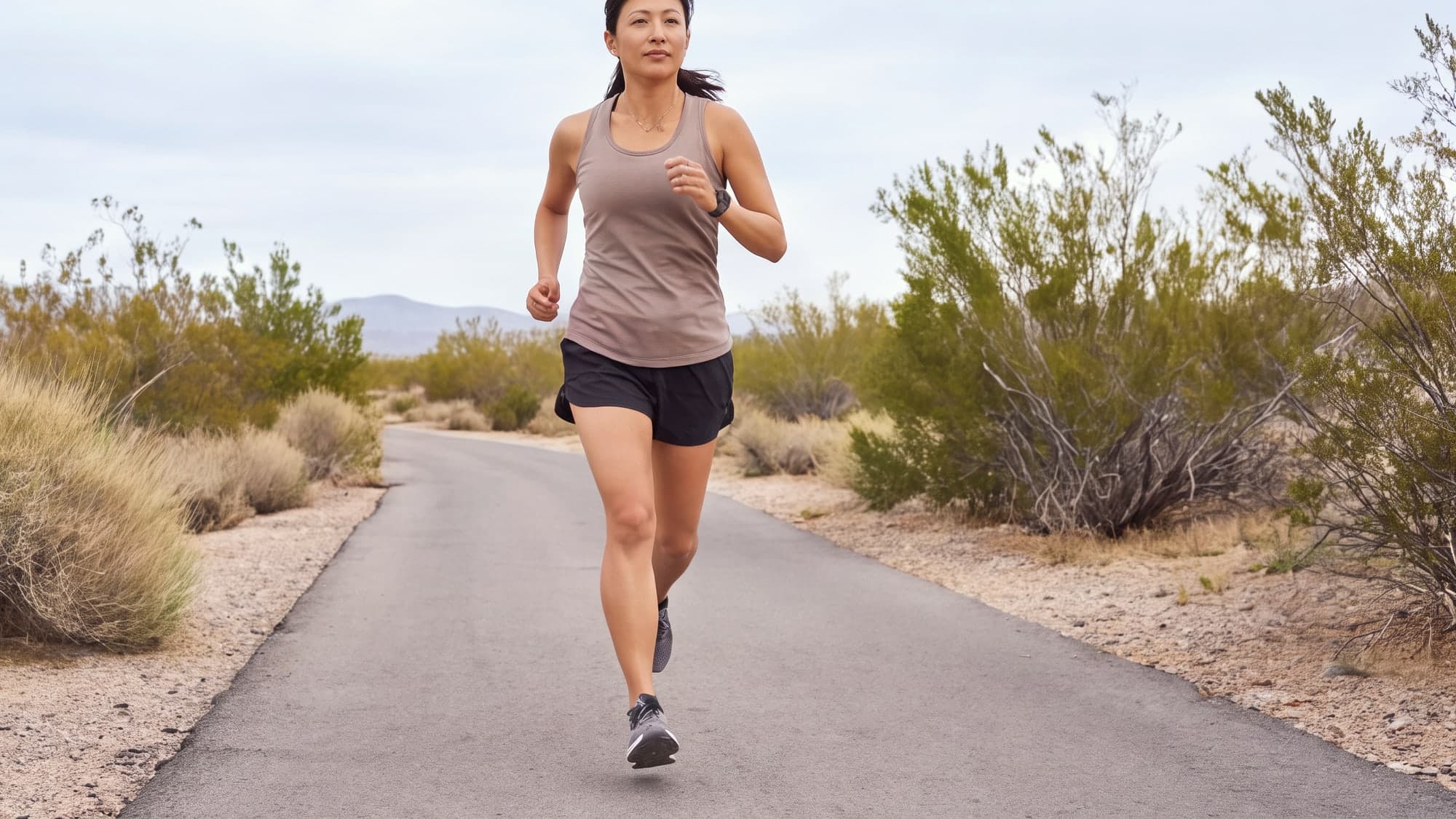 A woman running on a paved desert wash trail