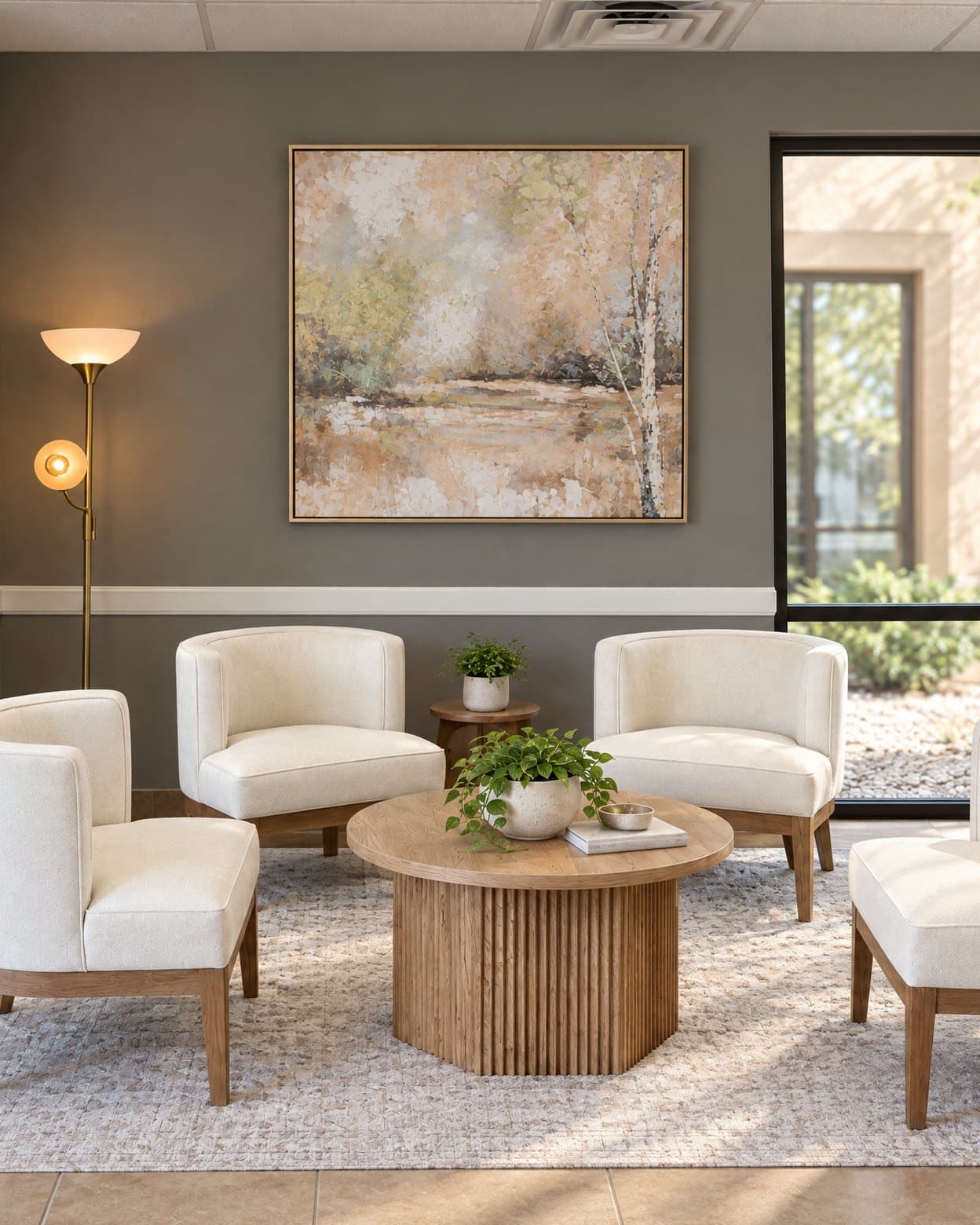 The lobby at GIOSTAR Longevity & Wellness in Henderson, four cream armchairs around a round wood table